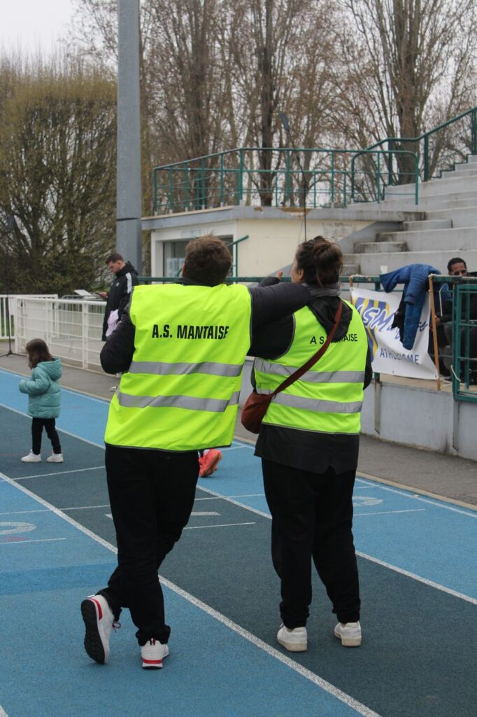 Deux bénévoles AS Mantaise sur la piste du stade