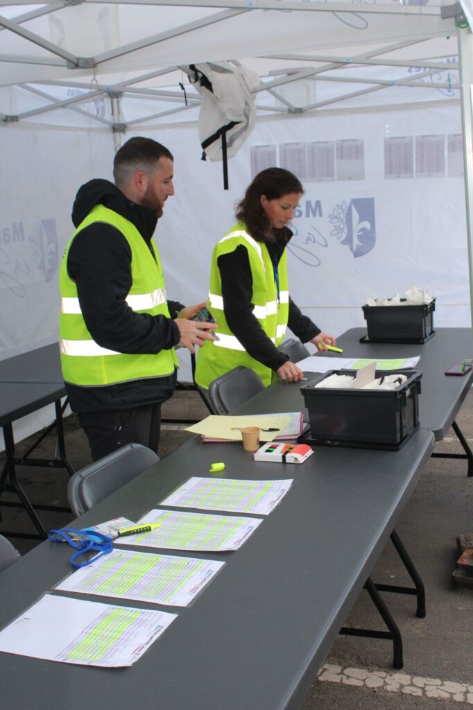 Bénévoles préparant les listes sous la tente